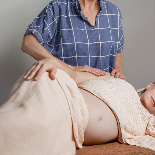 a woman on her side receiving pregnancy massage